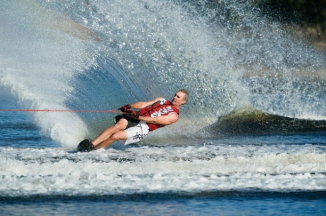 Man waterskiing, creating a large spray of water