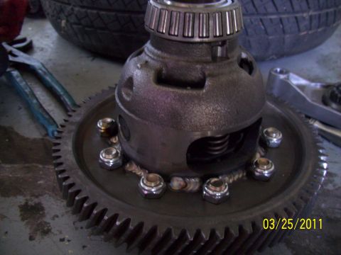1995 Ford Probe - A close-up view of a vehicle's differential and gear assembly, with tools and a tire in the background.