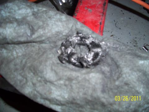 1995 Ford Probe - A close-up of a greasy metal part resting on a cloth, with a red object visible in the background.