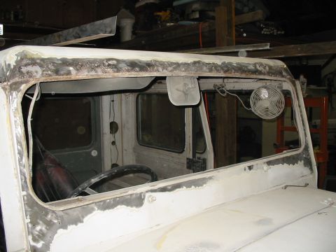 1974 Jeep CJ5 - The vehicle's interior is visible, with bodywork being done around the windshield frame.