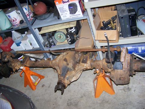 1992 Jeep YJ - A rear axle assembly is shown supported by jack stands in a cluttered garage or workshop.