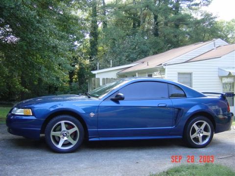 1999 Ford Mustang - Side profile of a blue 1999 Ford Mustang coupe with tinted windows.