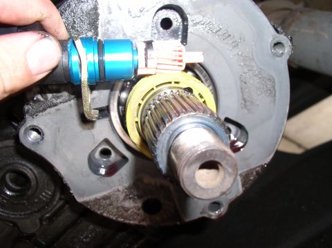 1988 Ford Bronco - Transfer case part with sensor and splined shaft, likely during a rebuild or repair.