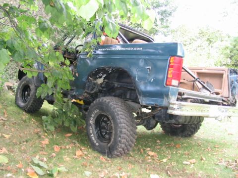 1986 Ford Bronco - This modified Ford Bronco shows significant body damage and off-road tires.