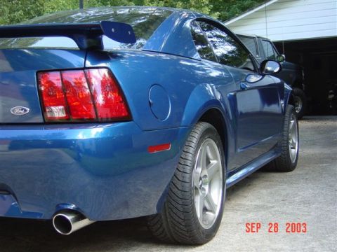 1999 Ford Mustang - Rear view of a blue 1999 Ford Mustang, showing its distinctive taillights and spoiler.