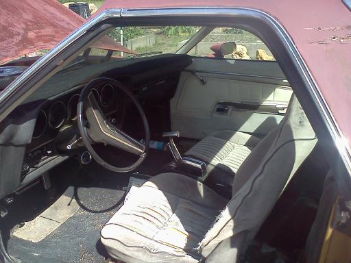 Interior of a red pickup truck, showing dashboard, steering wheel, and seats