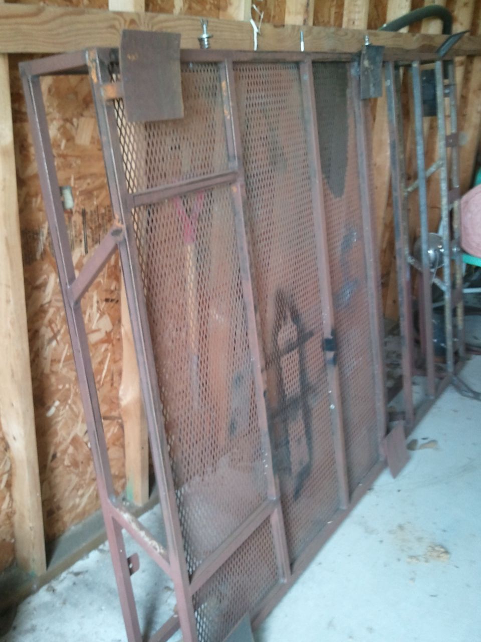 metal rack sections leaning against a wall in a garage