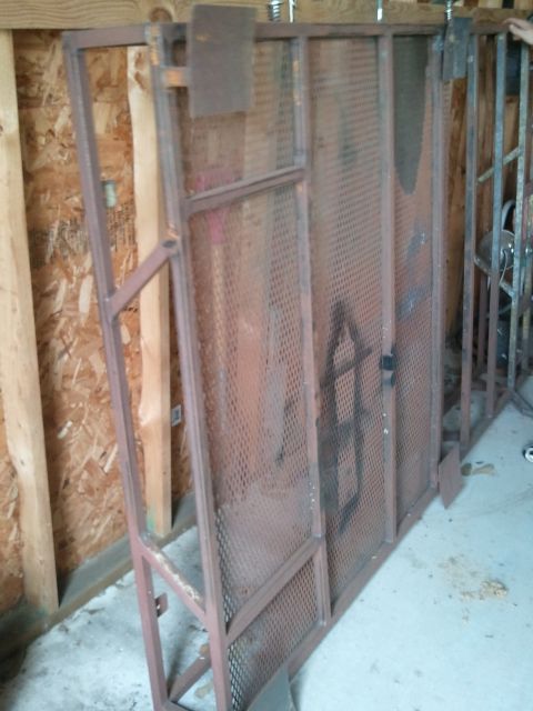 1995 Ford Bronco - A metal rack with diamond pattern mesh is leaning against a wall in a garage.
