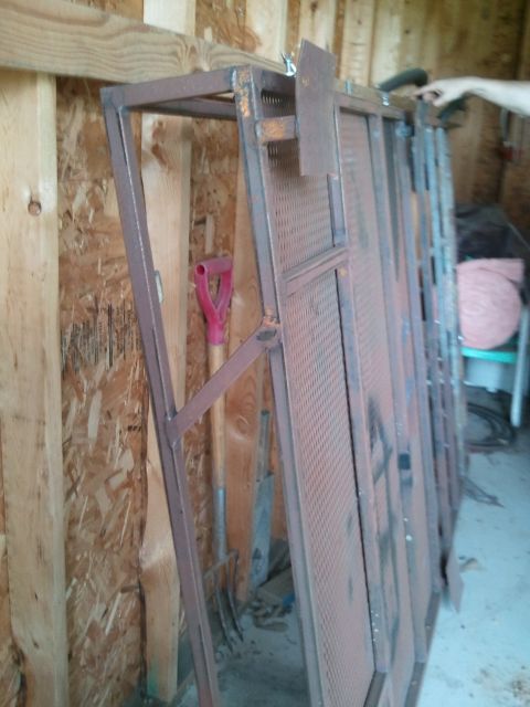 1995 Ford Bronco - Metal rack with perforated panels stored indoors, next to gardening tools.