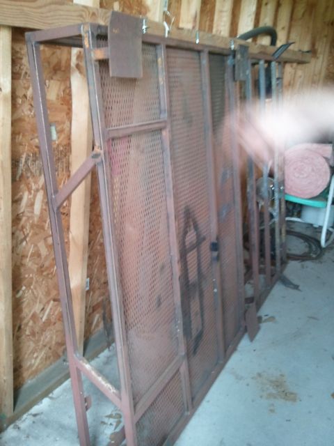 1995 Ford Bronco - A metal rack with perforated panels is stored indoors, leaning against a wooden wall.