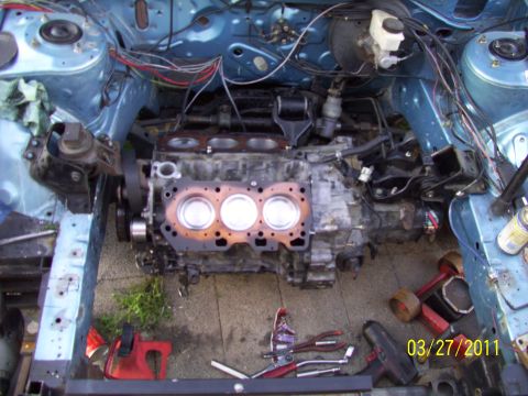1995 Ford Probe - Engine block disassembled for repair, with tools laid out on the ground.