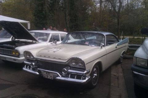 1991 Ford LTD Crown Victoria - 1957 Dodge Custom Royal coupe parked next to another car with its hood open.