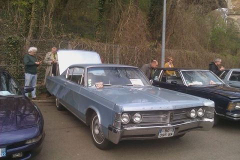 1991 Ford LTD Crown Victoria - A light blue 1967 Chrysler Imperial is displayed with its hood open, alongside other vehicles at an outdoor event.