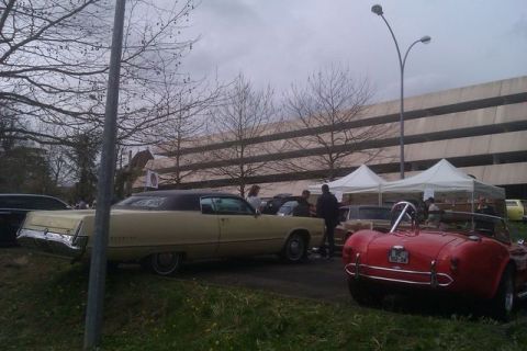 1991 Ford LTD Crown Victoria - A yellow sedan with a black vinyl roof is parked next to other vehicles at an outdoor event.