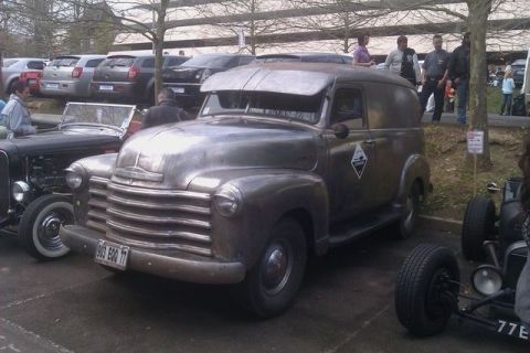 1991 Ford LTD Crown Victoria - A vintage panel van is parked next to a hot rod at an outdoor car show.