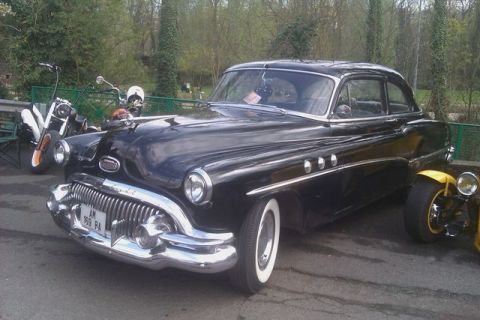1991 Ford LTD Crown Victoria - A classic black Buick sedan from the early 1950s is displayed at an outdoor event.