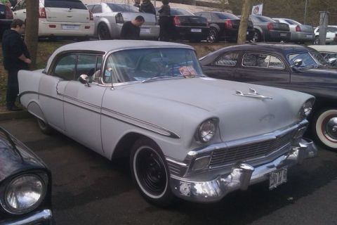 1991 Ford LTD Crown Victoria - A white 1956 Chevrolet Bel Air two-door hardtop photographed from the front three-quarter at an outdoor car meet, showing its chrome grille…