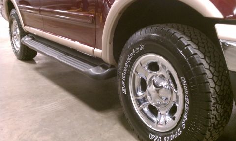 1999 Ford Expedition - Close-up of the side step and wheel of a 1999 Ford Expedition.