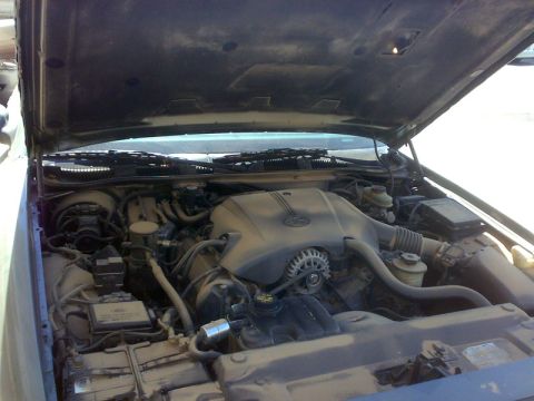 2001 Mercury Grand Marquis - The engine bay of a 2001 Mercury Grand Marquis is visible with the hood open, revealing the engine components.