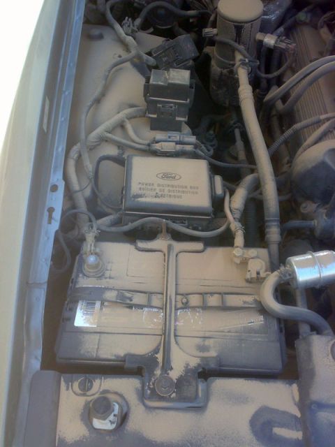 2001 Mercury Grand Marquis - The engine bay shows a Ford power distribution box and battery, with visible dust and grime.