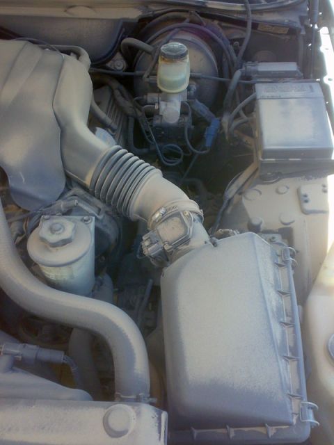 2001 Mercury Grand Marquis - Close-up view of a dusty engine bay, showing various components and hoses.