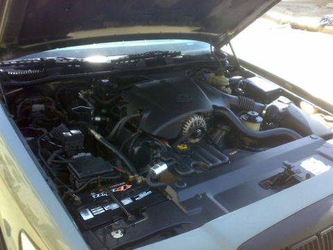 2001 Mercury Grand Marquis - The engine bay of a 2001 Mercury Grand Marquis is visible with the hood open, revealing the engine components and battery.