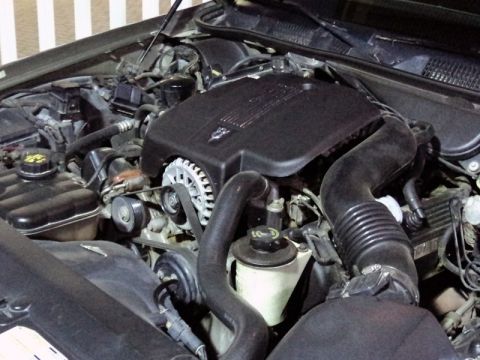 2001 Mercury Grand Marquis - The engine bay of a 2001 Mercury Grand Marquis shows its V8 engine with a black cover and visible alternator.