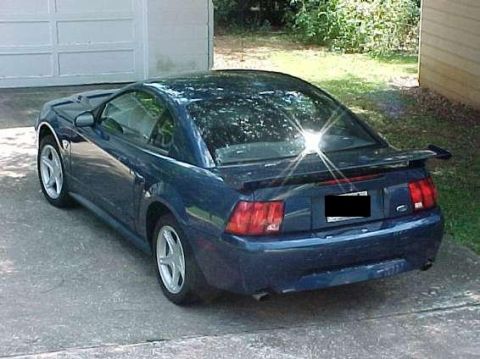 1999 Ford Mustang - Rear view of a dark blue 1999 Ford Mustang coupe with a spoiler.