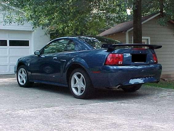 blue Mustang parked in driveway, rear view