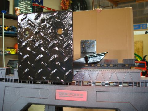 1995 Ford Bronco - A black diamond plate metal bracket is shown, mounted on a sawhorse in a workshop setting.