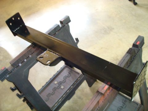 1995 Ford Bronco - A black metal bracket, likely a vehicle part, is shown resting on sawhorses.