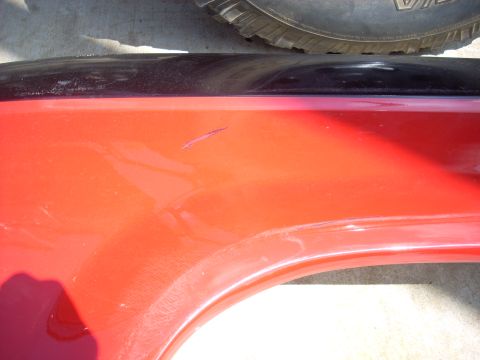 1992 Ford Ranger - A scratch is visible on the red fender of this vehicle part.