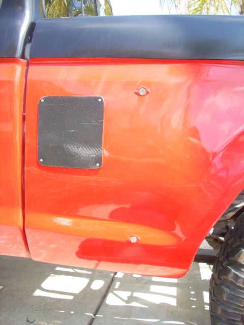 1992 Ford Ranger - Side view of a red truck a carbon fiber panel and two small lights on the body.