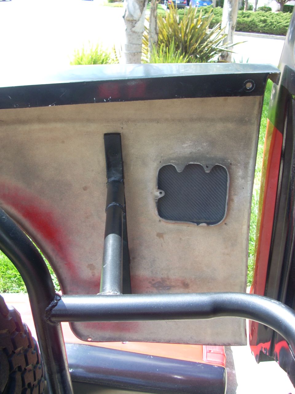 Interior door panel with a roll cage bar and a carbon fiber insert