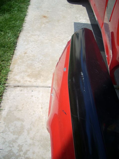 1992 Ford Ranger - A close-up view of a red truck's fender and black trim piece.