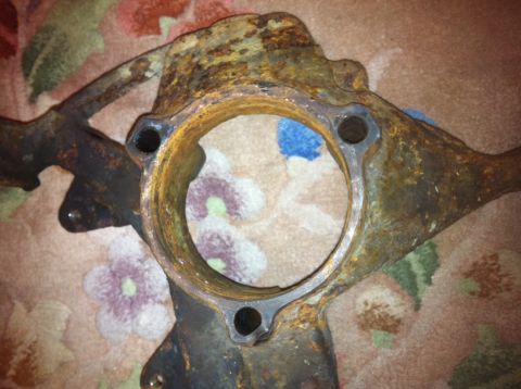 1972 Ford Ranchero - This heavily rusted vehicle part appears to be a steering knuckle, likely from an older car or truck.