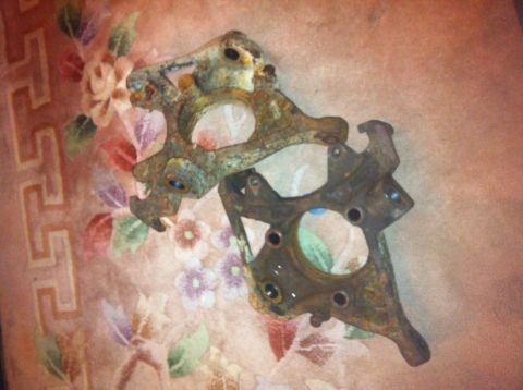 1972 Ford Ranchero - Pair of rusty steering knuckles, likely from an older vehicle, resting on a patterned fabric.