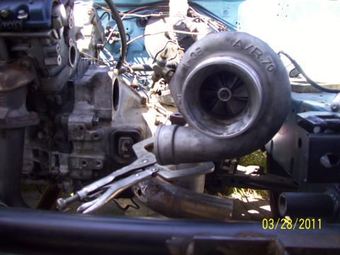 1995 Ford Probe - A turbocharger with A/R.70 marking is clamped to an engine during installation.