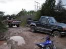 1989 Ford Bronco - Two trucks are stuck in the mud, with an ATV visible in the foreground.