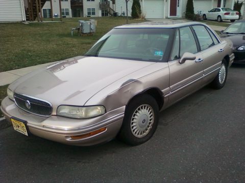 2004 Acura TL - This tan sedan, likely a 1997 model, has a noticeable dent on its front fender and a prominent chrome grille.