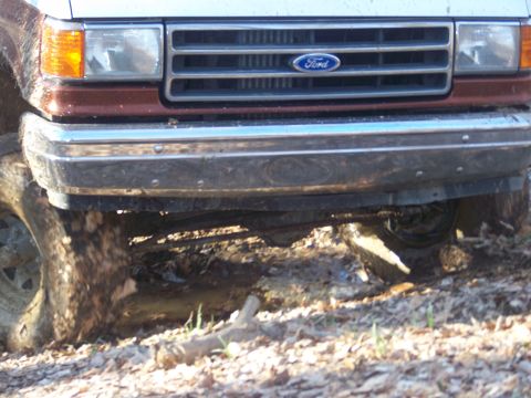 1989 Ford Bronco - Front view of a 1989 Ford Bronco, showing the grille and bumper while navigating rough terrain.