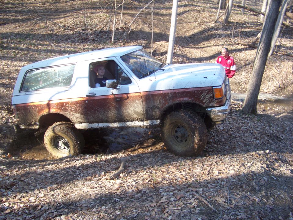 1989 Ford Bronco stuck in mud with driver visible