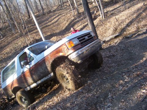 1989 Ford Bronco - This 1989 Ford Bronco is navigating a challenging off-road trail through a forest.