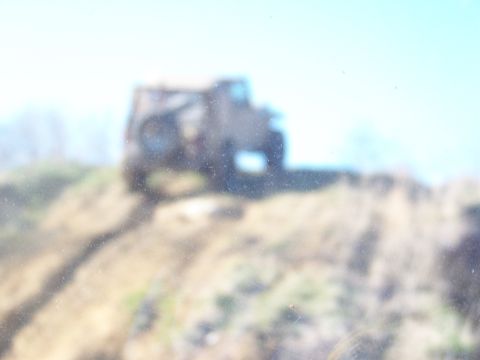 1989 Ford Bronco - A vehicle navigates a steep, dirt incline under a clear sky.