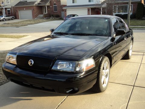 2004 Mercury Grand Marquis - Front 3/4 view of a black 2004 Mercury Grand Marquis sedan parked on a suburban driveway.