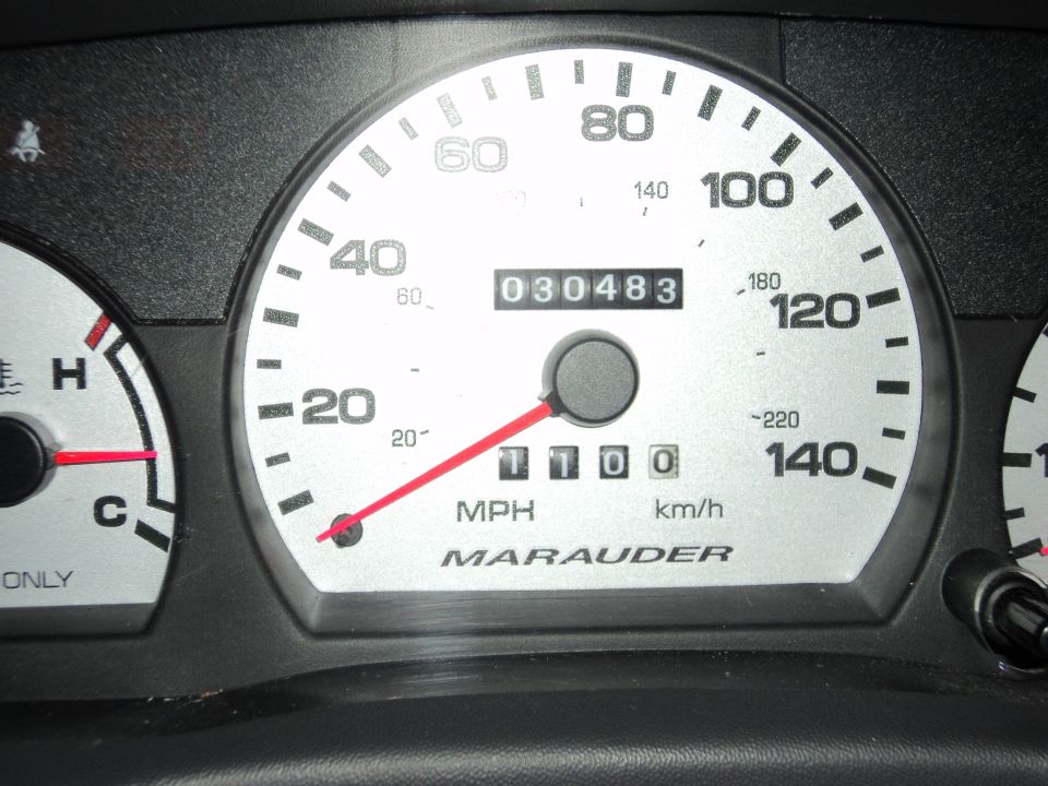 Marauder speedometer cluster reading 030483 miles, needle at zero, with temp gauge at left.
