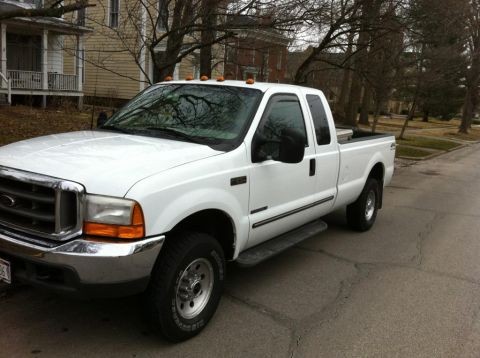 2000 Ford F-250 - A white Ford pickup truck is parked on a residential street with houses in the background.