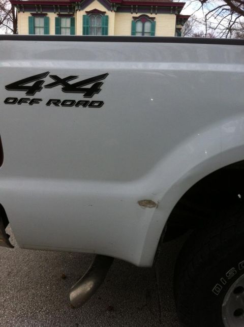 2000 Ford F-250 - A white 2000 Ford F-250 pickup truck is seen from the side, displaying its 4x4 Off Road decal.