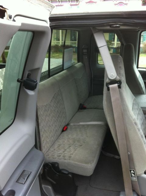 2000 Ford F-250 - The interior of a 2000 Ford F-250 pickup truck is visible, focusing on the rear seating area and door trim.