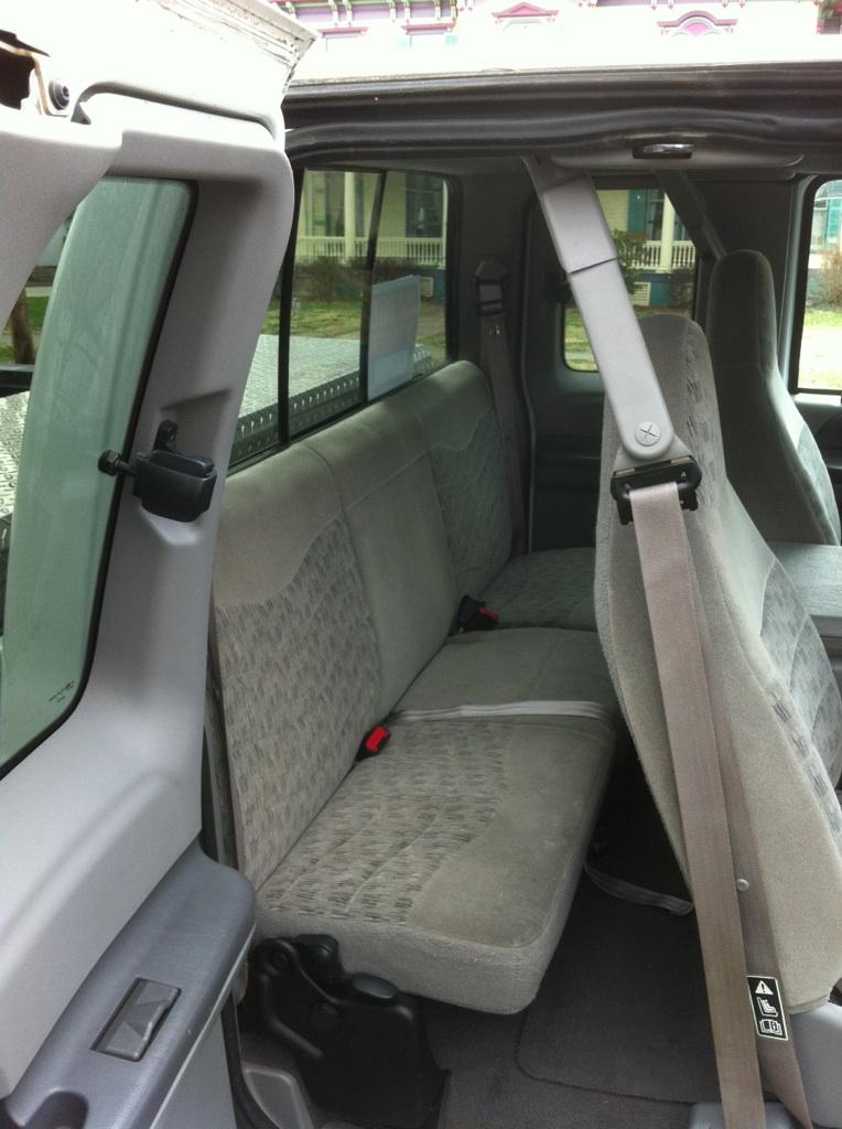 Interior view of a 2000 Ford F-250 showing the rear bench seat and door panel